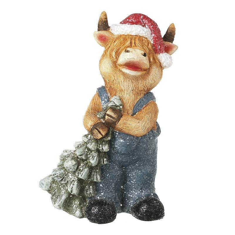 highland cow with red santa hat and blue dungarees on carrying a green christmas tree