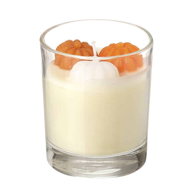 pumpkins inside a candle with wick in glassware orange and white