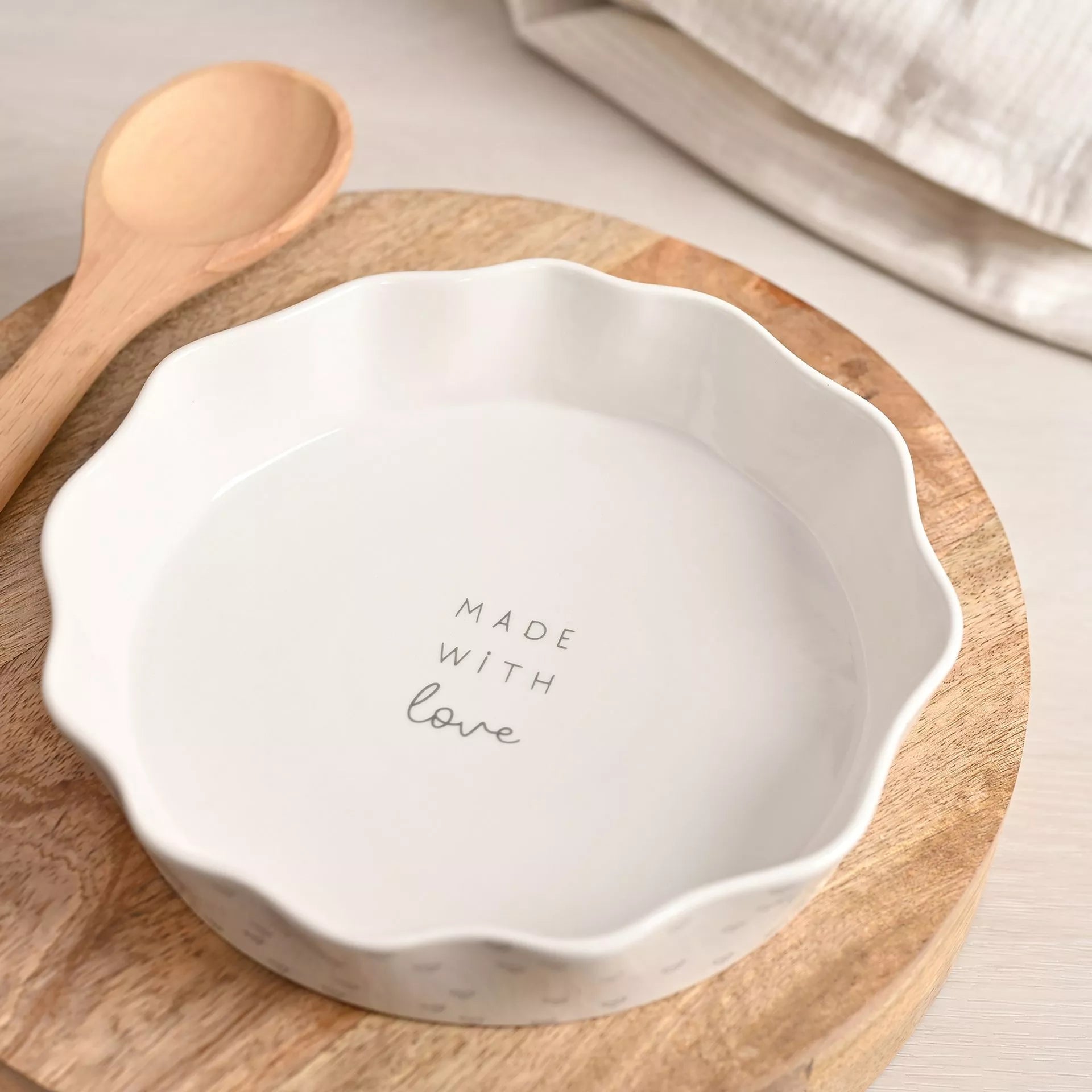 White ceramic pie dish with 'Made with Love' text on the inside and lots of mini hearts 
