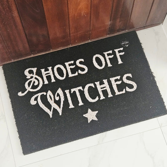 black Doormat with 'Shoes Off Witches' white text and star 40 by 60cm