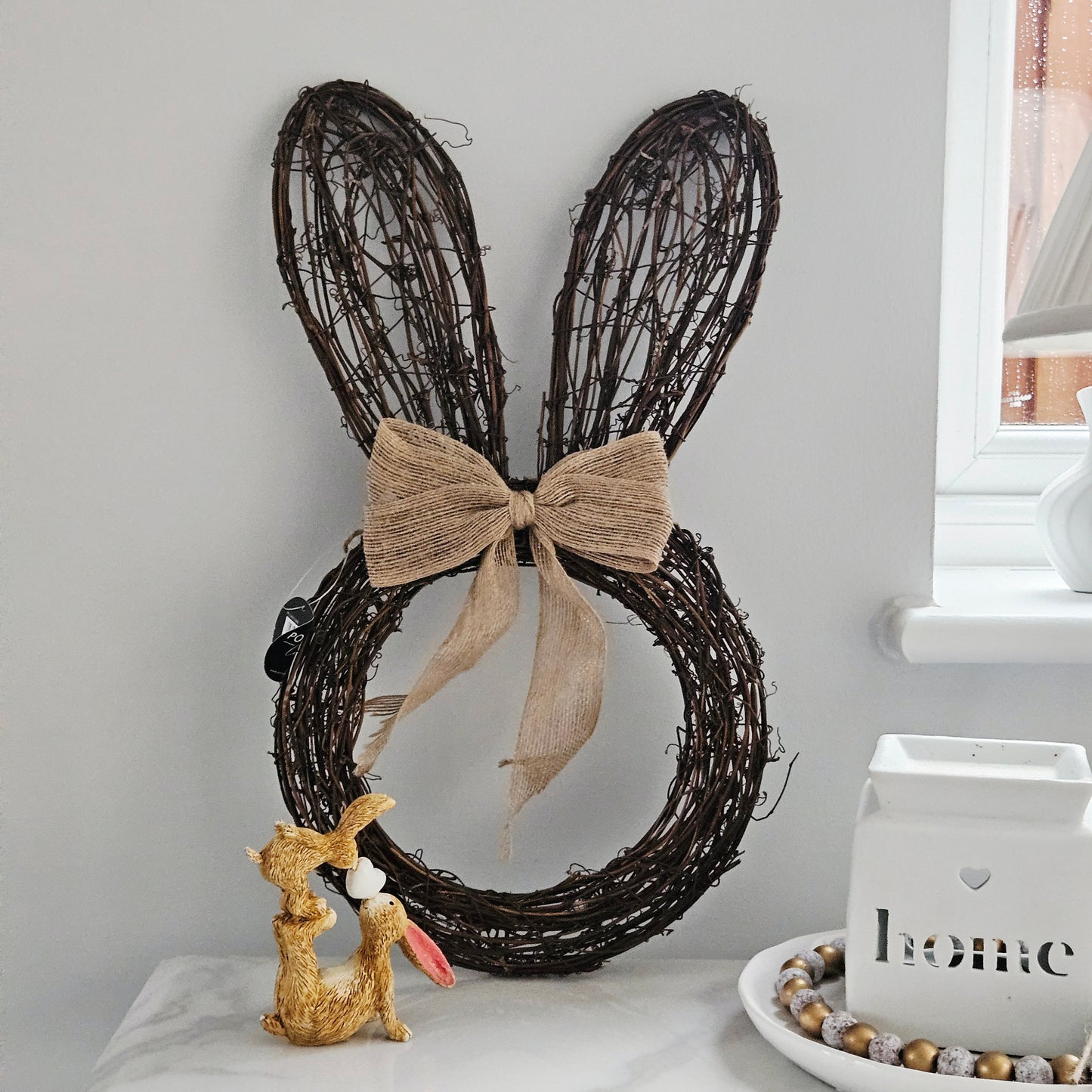 Decorative wreath with bunny ears and a bow made from rattan