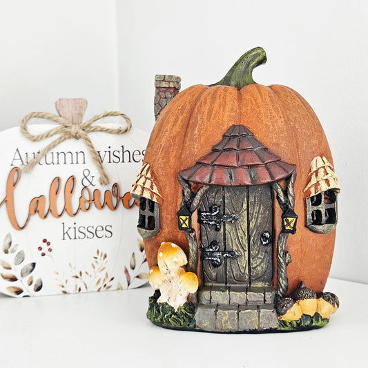 Pumpkin-shaped fairy house with a door and windows and led lighting