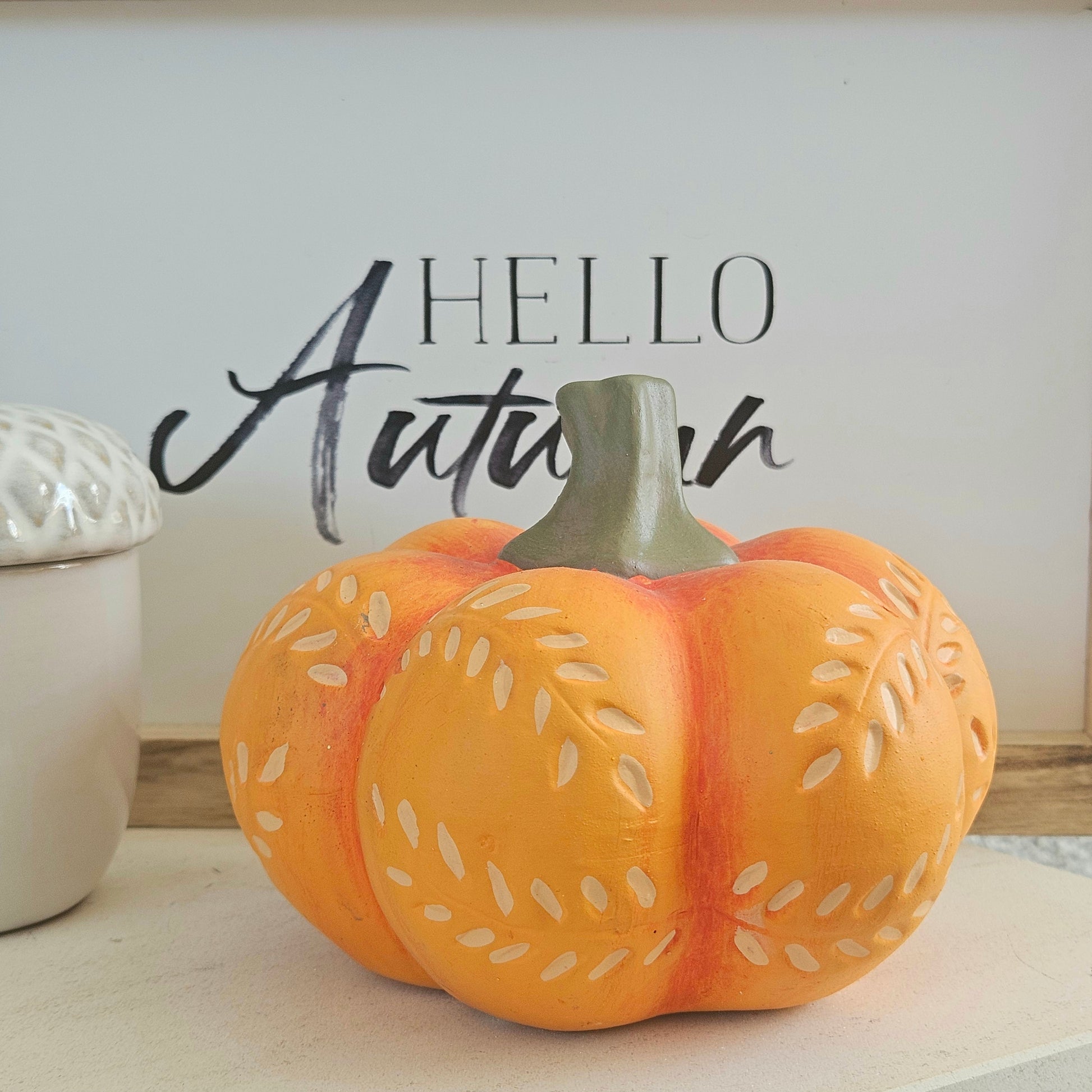 Decorative orange pumpkin with cut-out patterns and green stalk