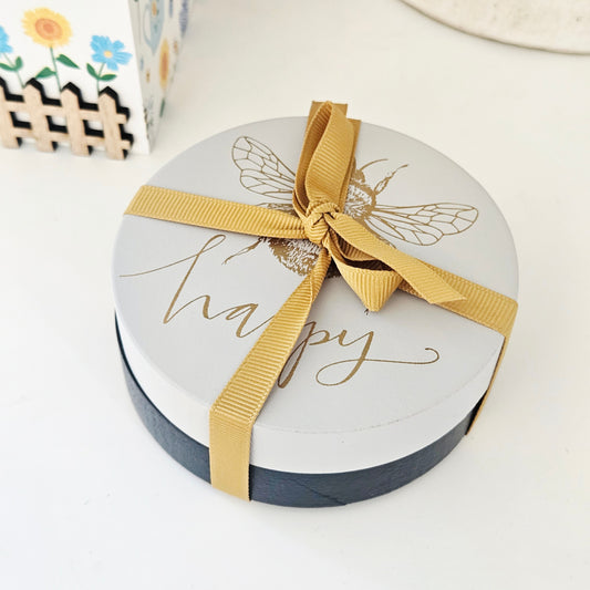 2 bee happy wooden coasters in white and black with gold ribbon