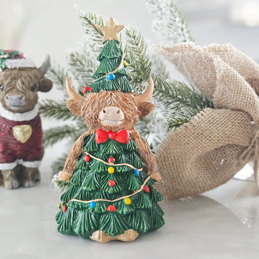 Highland cow dresses in a christmas tree outfit with star and baubles 