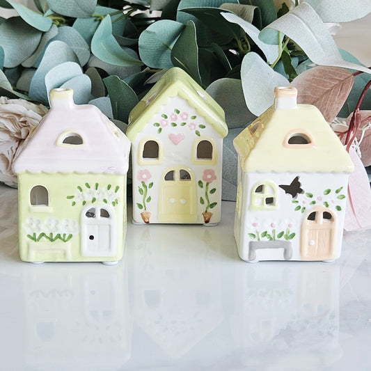 Three small ceramic house-shaped led  decorative designs with doors flowers pastel colours