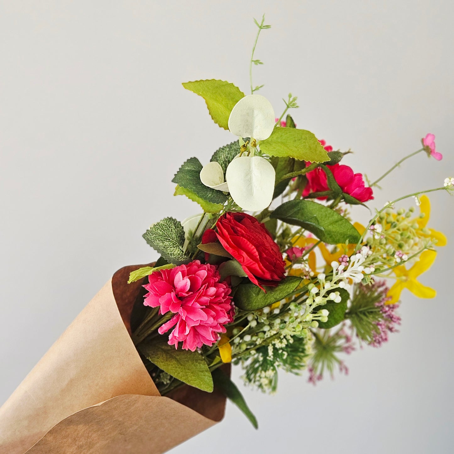 Red wildflower Bouquet of colourful flowers in a brown paper cone