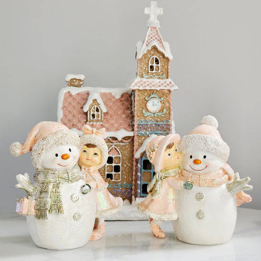 Decorative snowman figurines with sweet girl wearing pink hats and scarves hugging