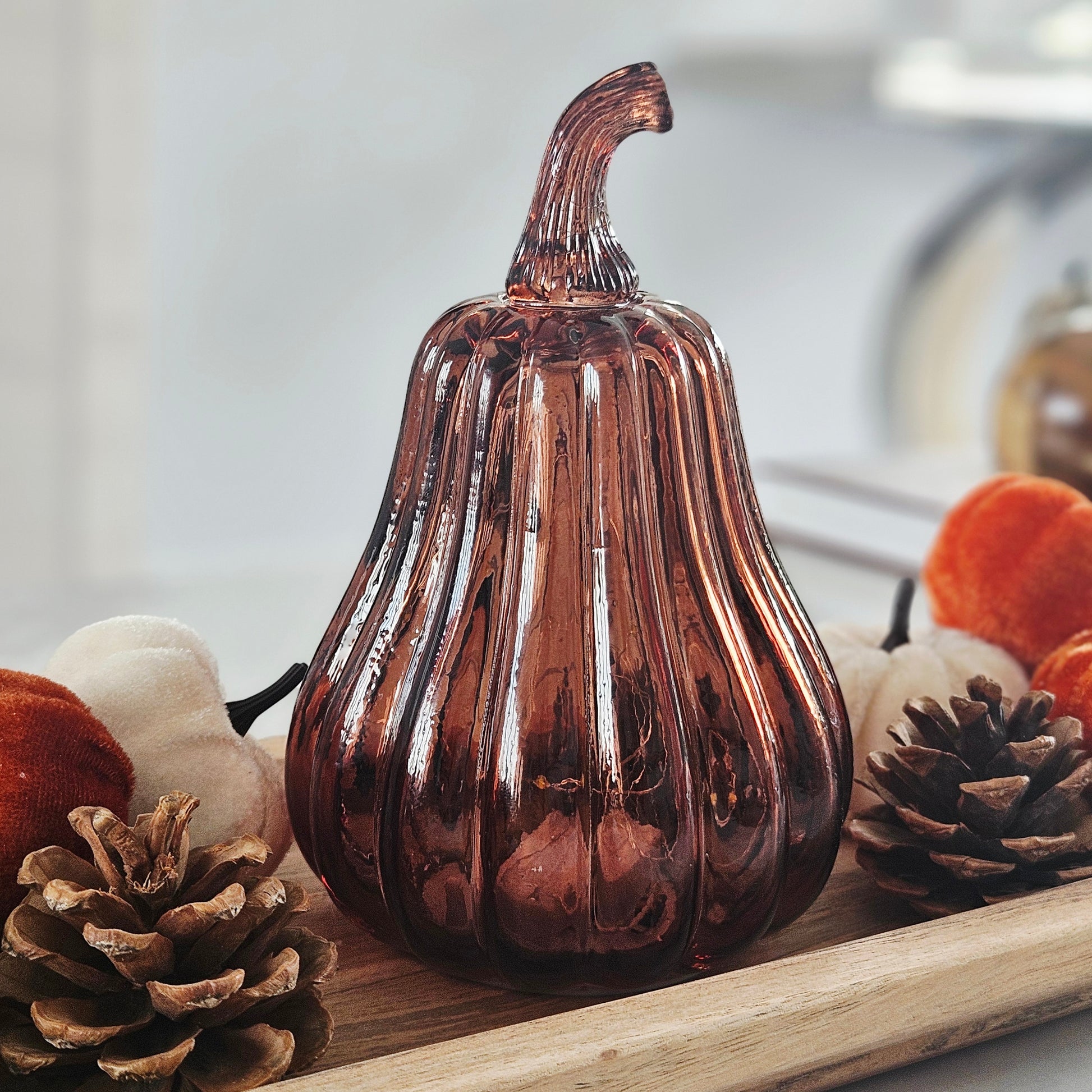 A ribbed amber led glass pumpkin with a curved stem, perfect for autumn decor