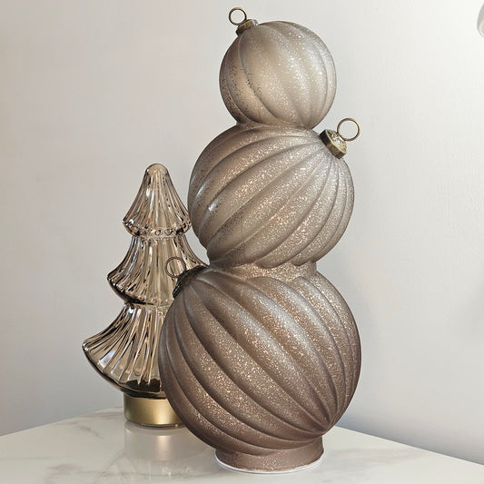 A three-tiered glass led bauble Christmas ornament in a glittery champagne beige colour, 