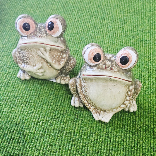 Two frog-shaped ornaments posing 