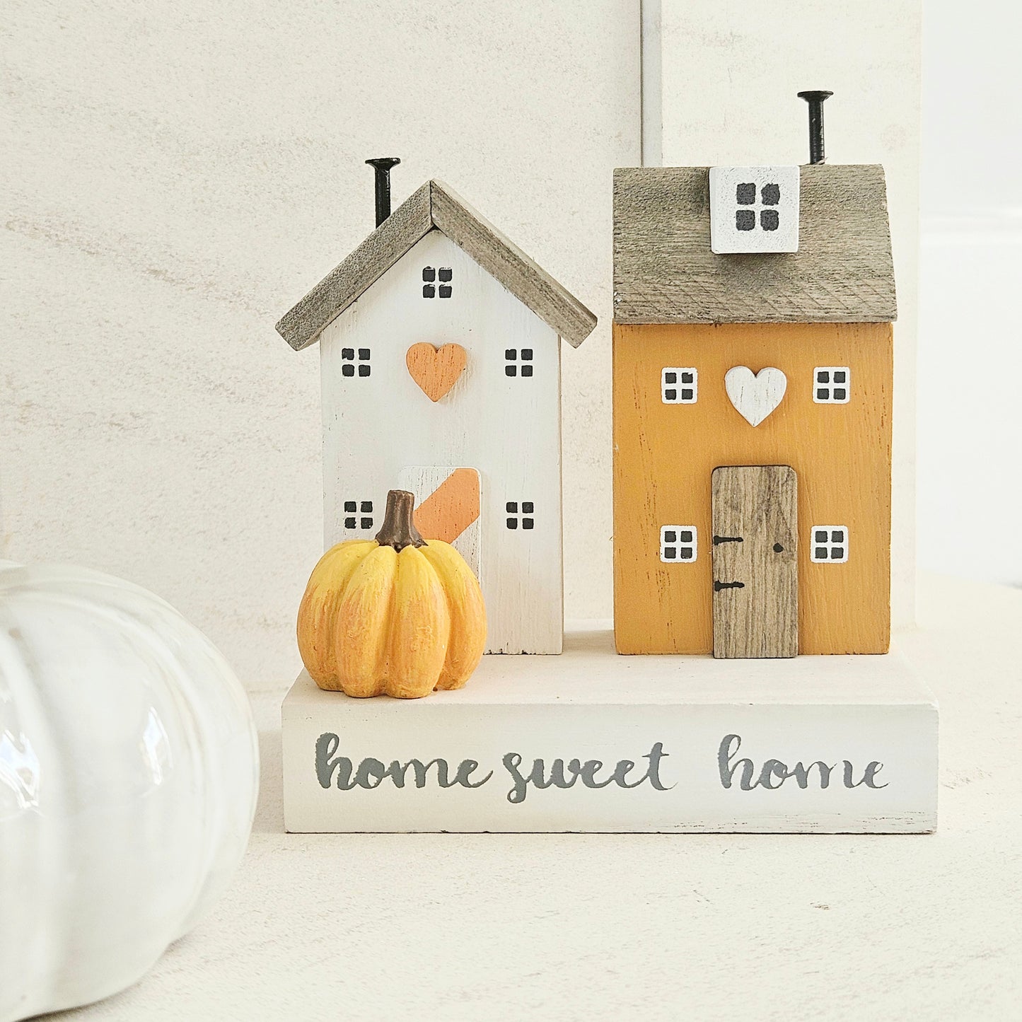 Decorative wooden houses with a pumpkin and 'home sweet home' text 