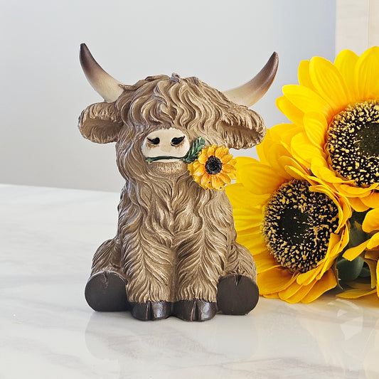 Decorative figurine of a Highland cow with a sunflower in it's mouth 16cm