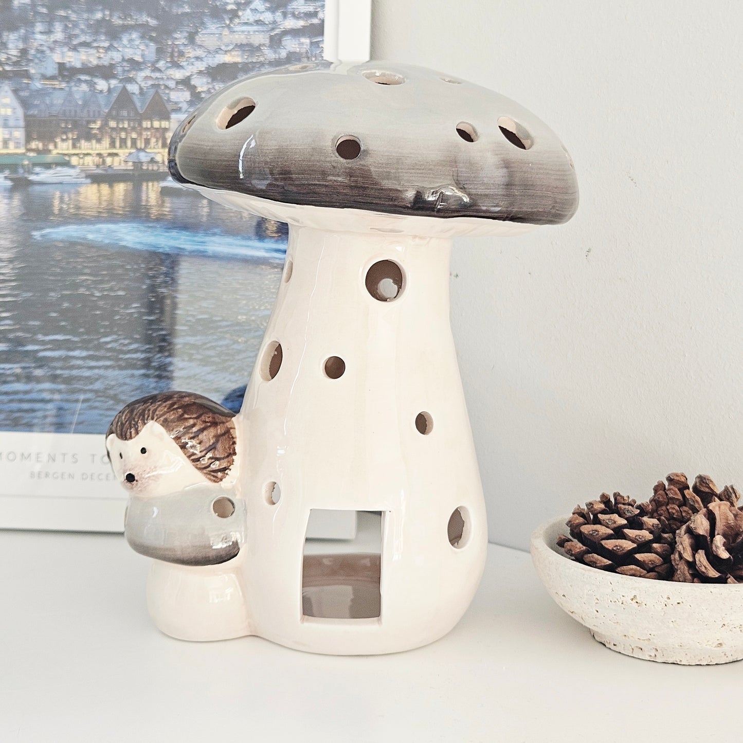 Ceramic mushroom-shaped tea light lantern with a hedgehog figurine perched on the side