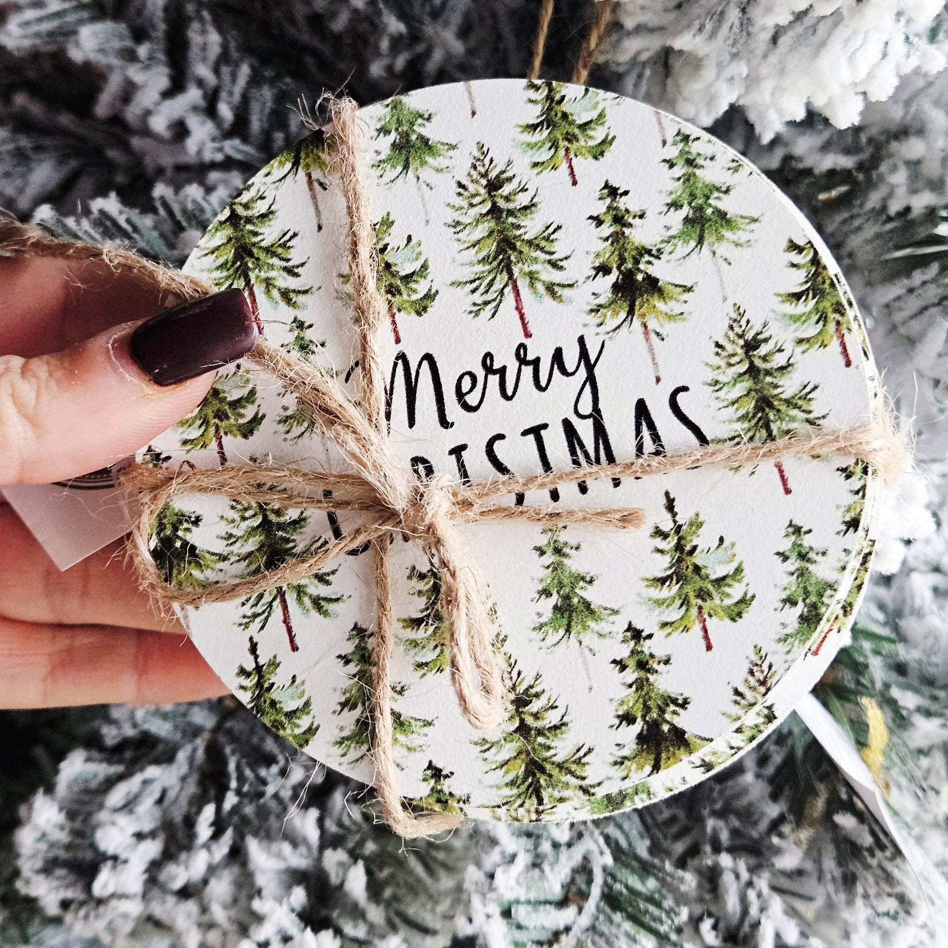 Set of four round coasters with Christmas tree pattern and 'Merry Christmas' text, tied with twine