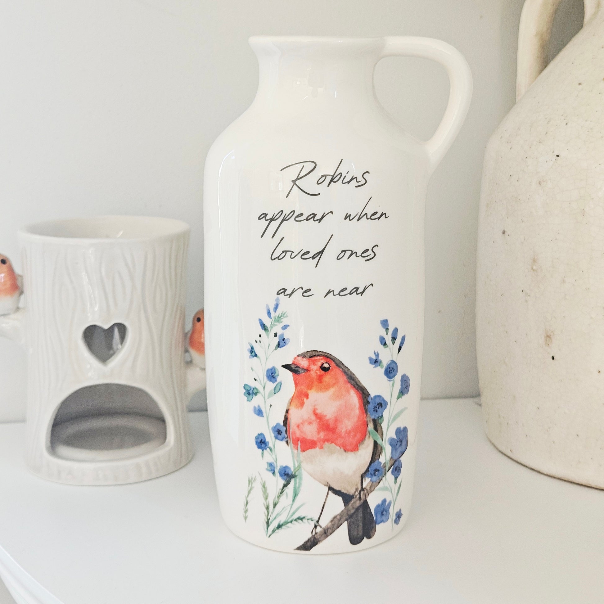 Vase with a robin design and text on a white surface