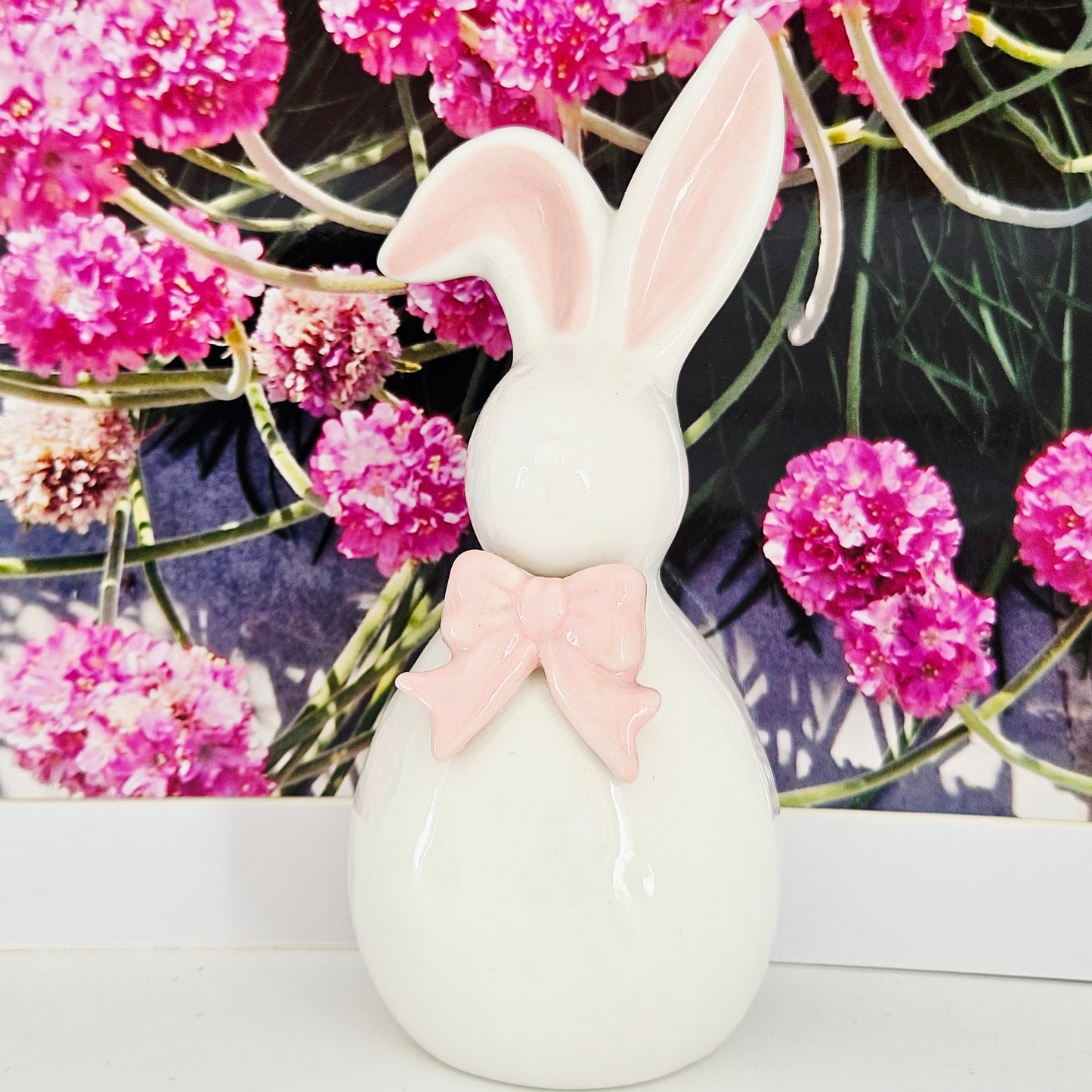 Ceramic bunny with pink bow and one ear up and one ear down