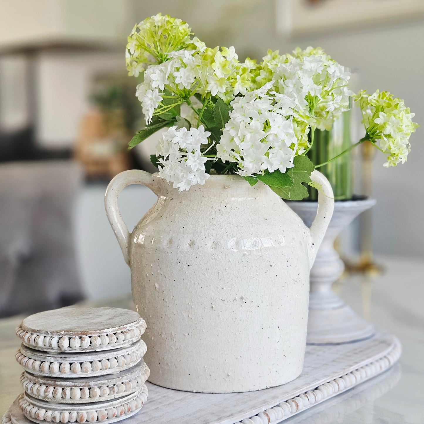 Handcrafted Jolee ceramic vase with decorative double handles in a neutral finish.
Hand-painted decorative ceramic vase with handles for modern rustic home styling.
Neutral ceramic vase with double handles displayed as decorative home décor.