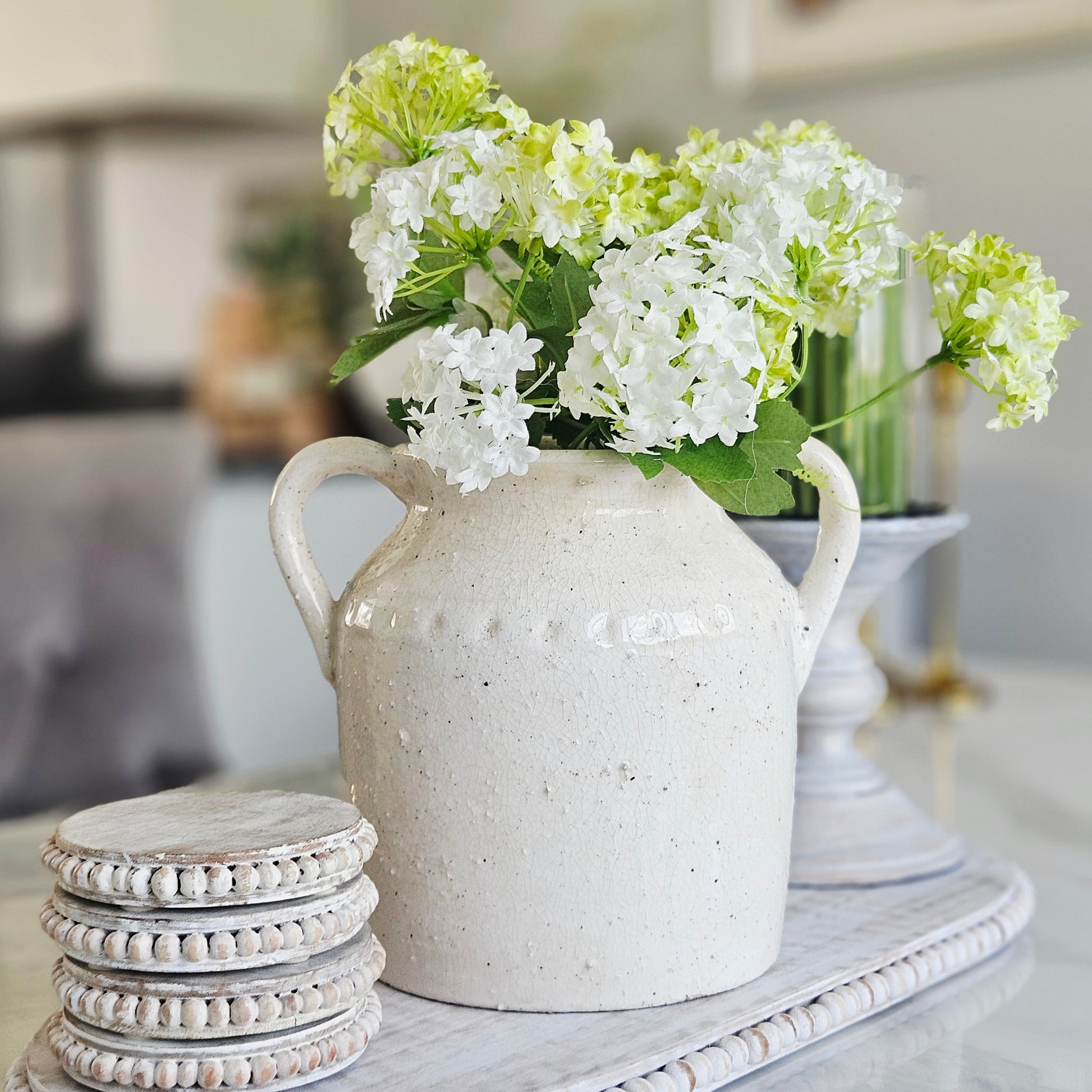 Handcrafted Jolee ceramic vase with decorative double handles in a neutral finish.
Hand-painted decorative ceramic vase with handles for modern rustic home styling.
Neutral ceramic vase with double handles displayed as decorative home décor.