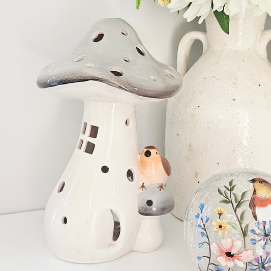 Decorative ceramic mushroom with a small house and robin bird figurine