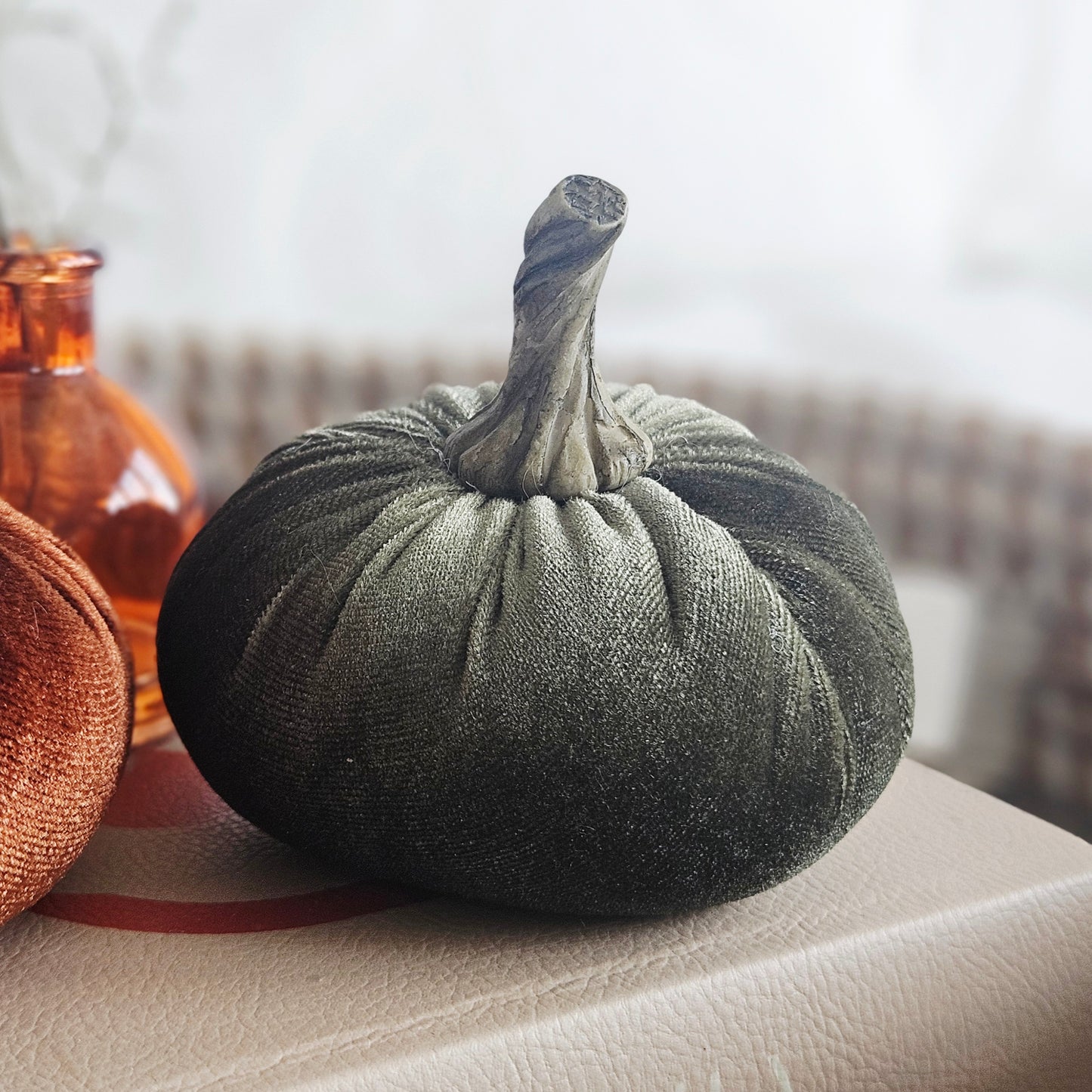 A dark olive green small velvet fabric pumpkin decoration with a textured stem, 