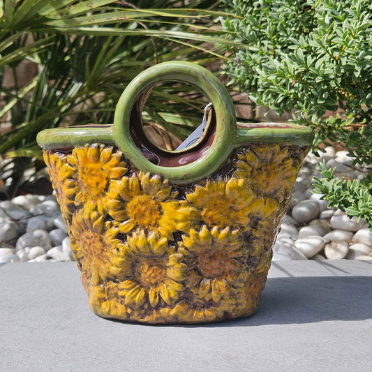 Ceramic basket planter with sunflower design and green handles 