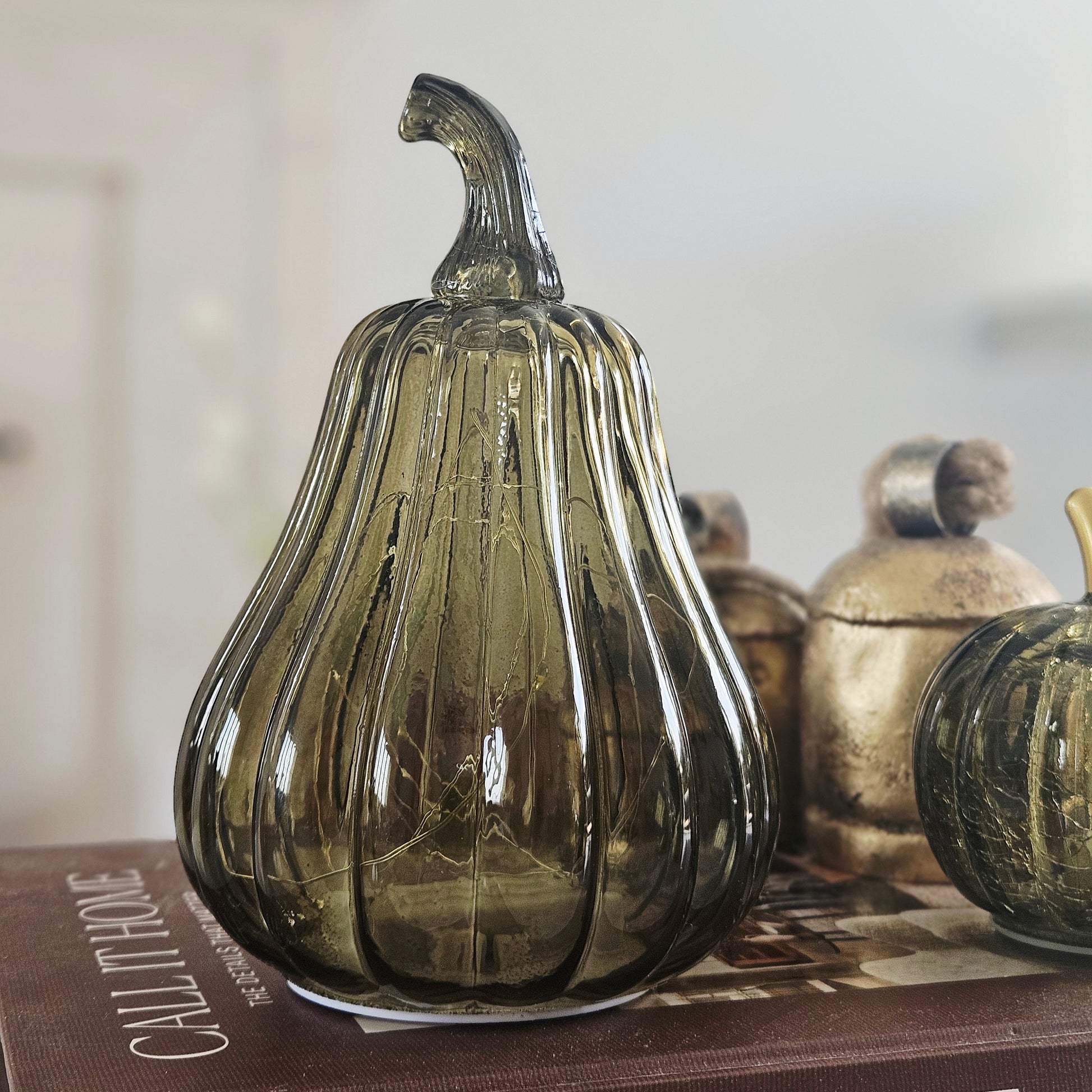 A ribbed glass led decorative pumpkin in smoky olive green perfect for autumn decor