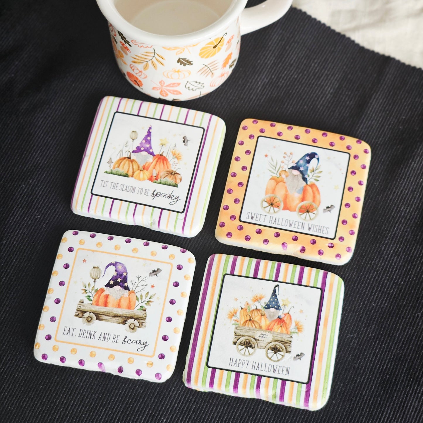 Set of four Halloween-themed coasters with pumpkins and gnomes on a white background.