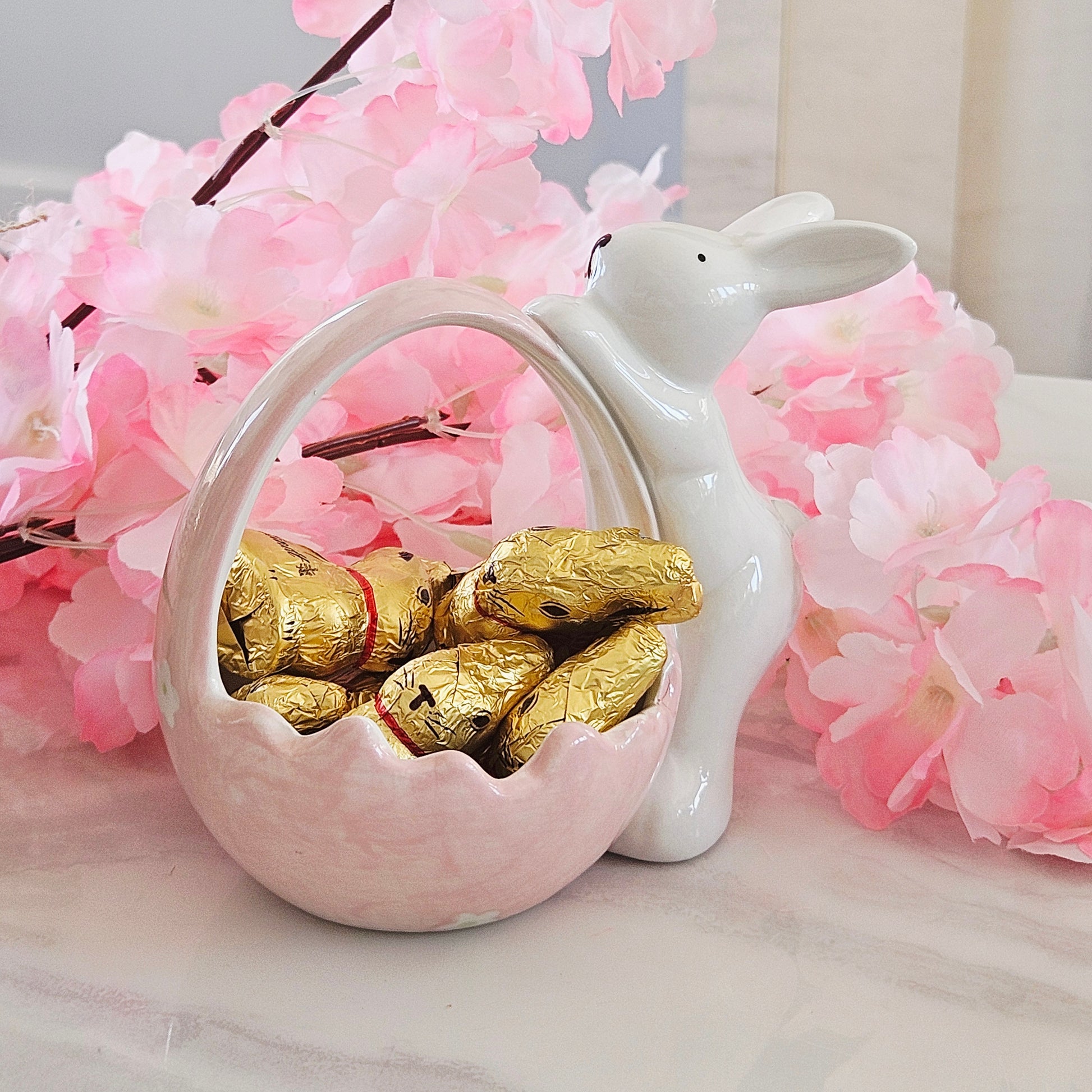 Decorative pink and white ceramic basket with bunny on the side