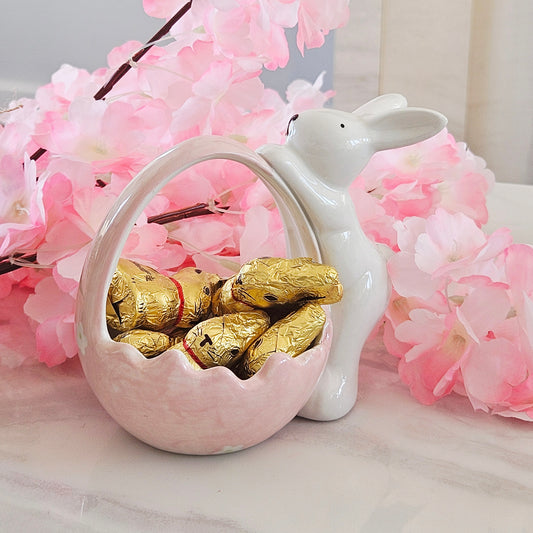 Decorative pink and white ceramic basket with bunny on the side