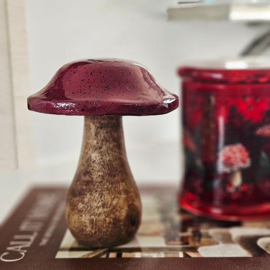 A small decorative mango wood mushroom figurine with a glossy dark red cap and a textured brown stem, 