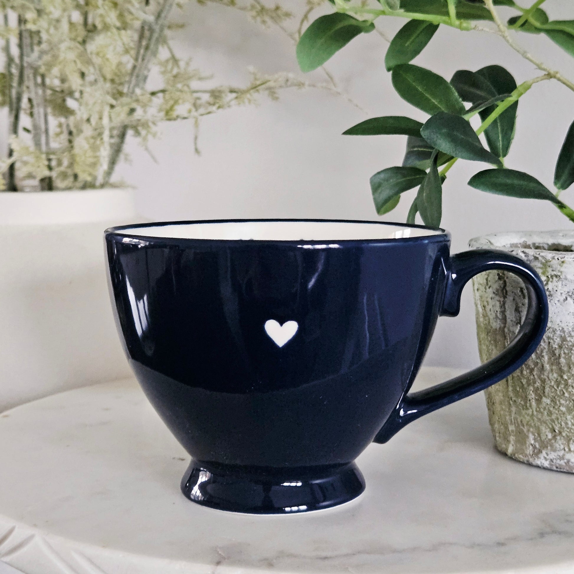 Navy blue mug with a white heart and multiple hearts inside 