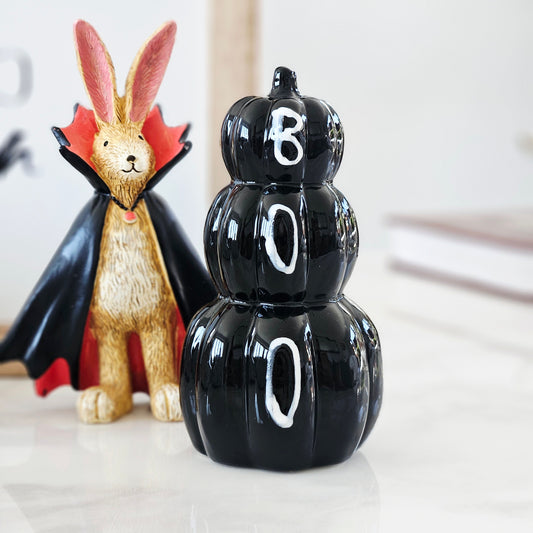 Black decorative pumpkin stack with 'BOO' letters written in white