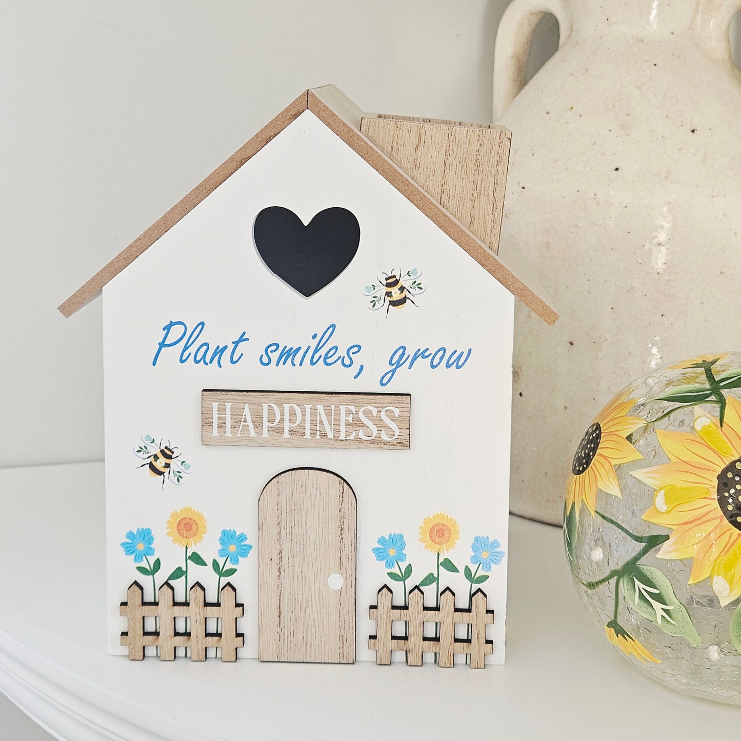 Decorative house-shaped sign with motivational quote and floral designed bee 