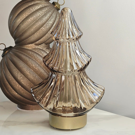 A ribbed, tiered glass led  Christmas tree ornament in a champagne gold finish with a gold base