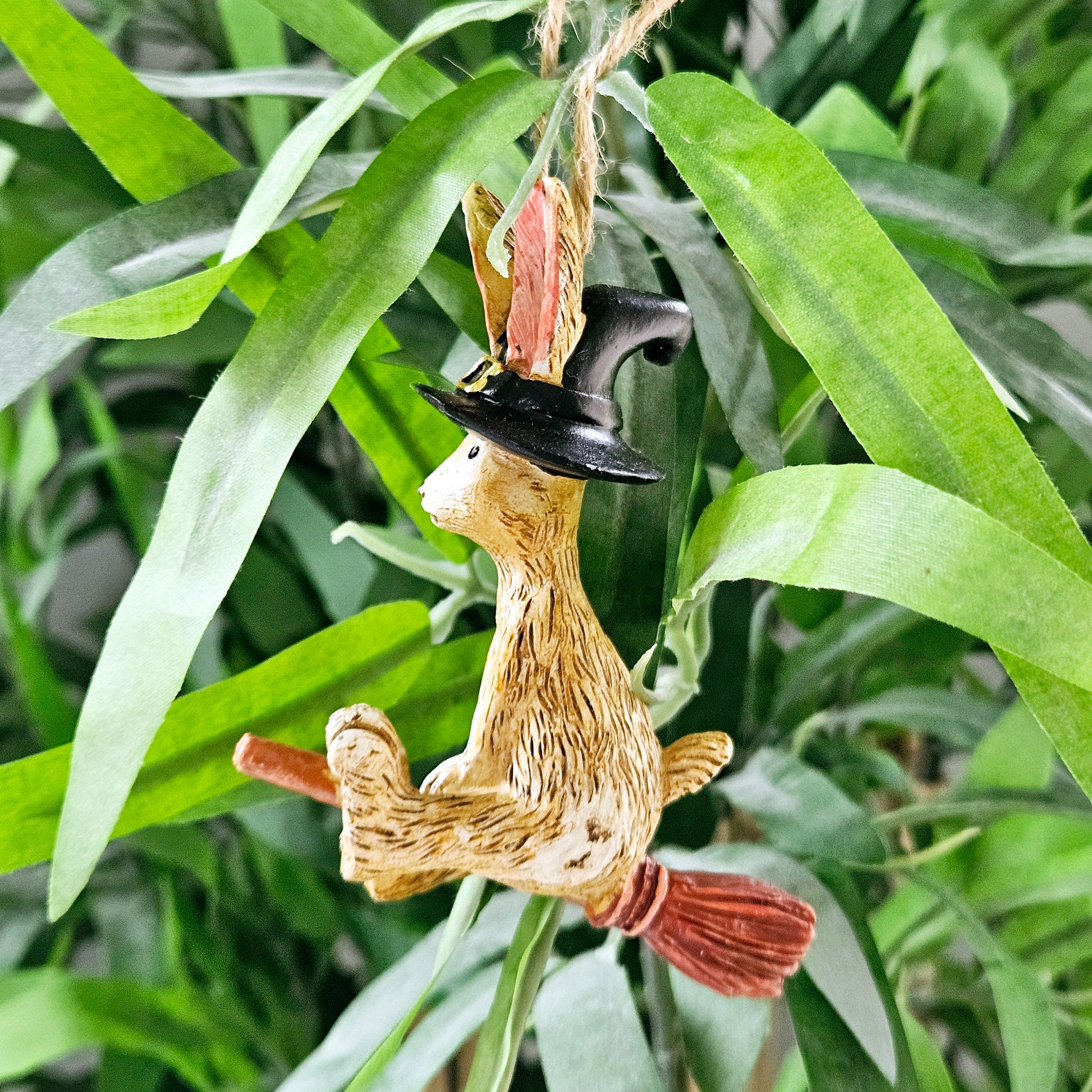 Witch bunny sitting on a broomstick with jute string to hang 