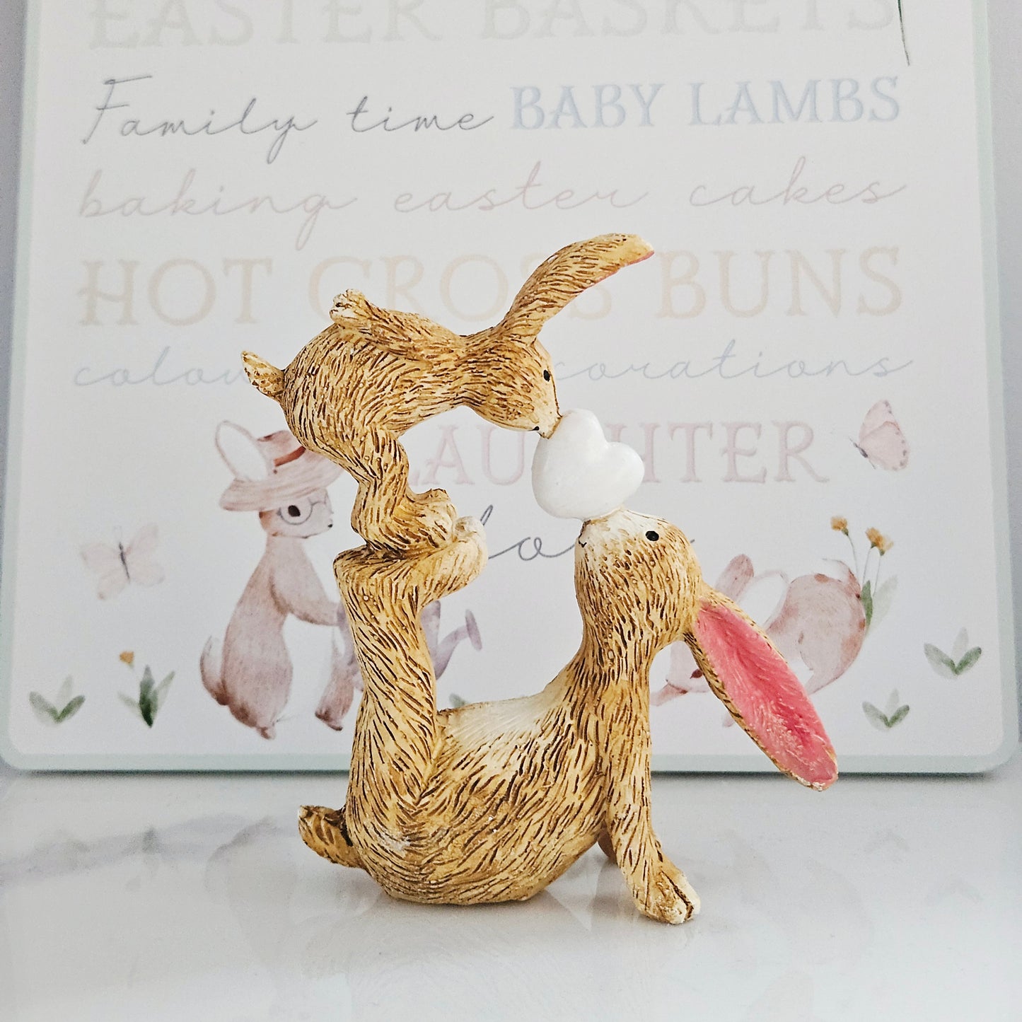 two jasper rabbits with a white heart in between there kiss