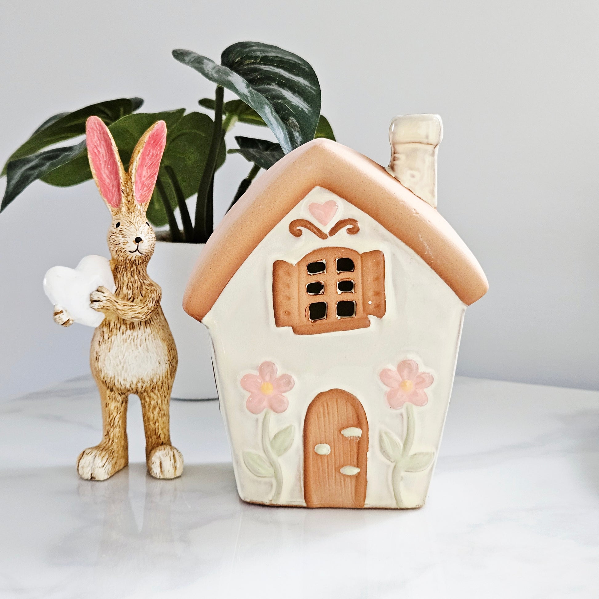 Ceramic tea light fairy shaped house with pastel tones and daisies
