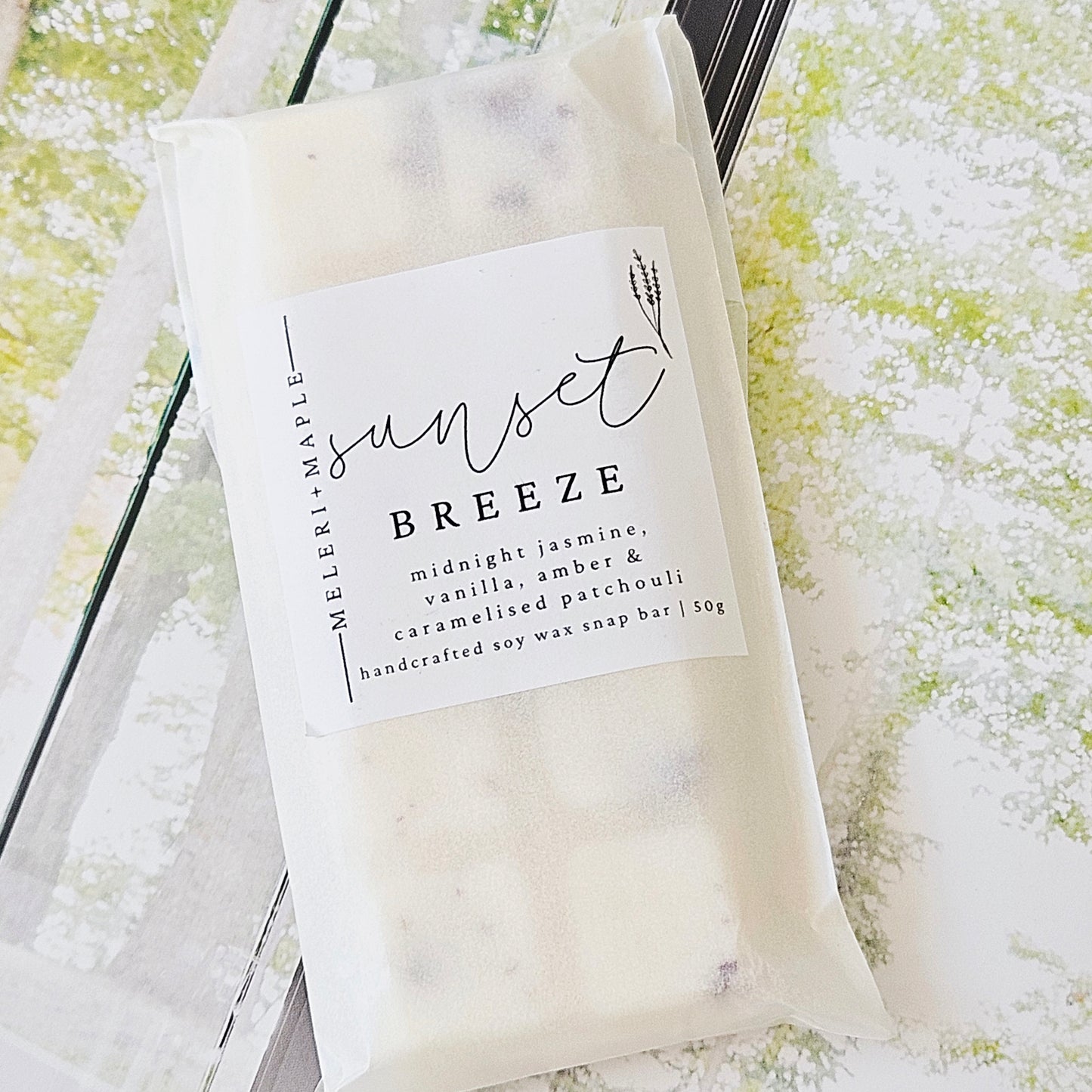 Scented wax melt snap bar with packaging labeled 'sunset breeze' on a white background by meleri and mapl