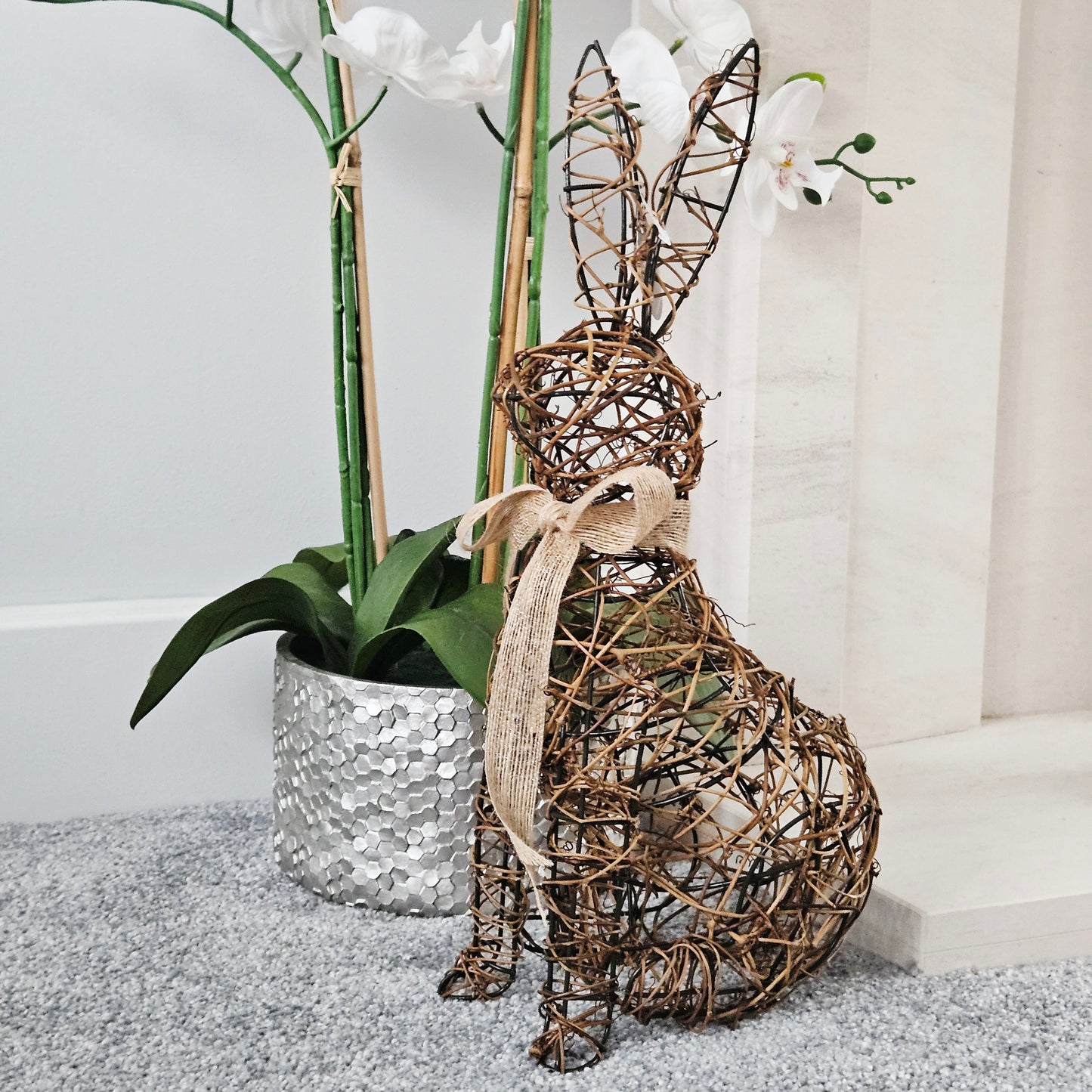Decorative rattan rabbit sculpture with bow