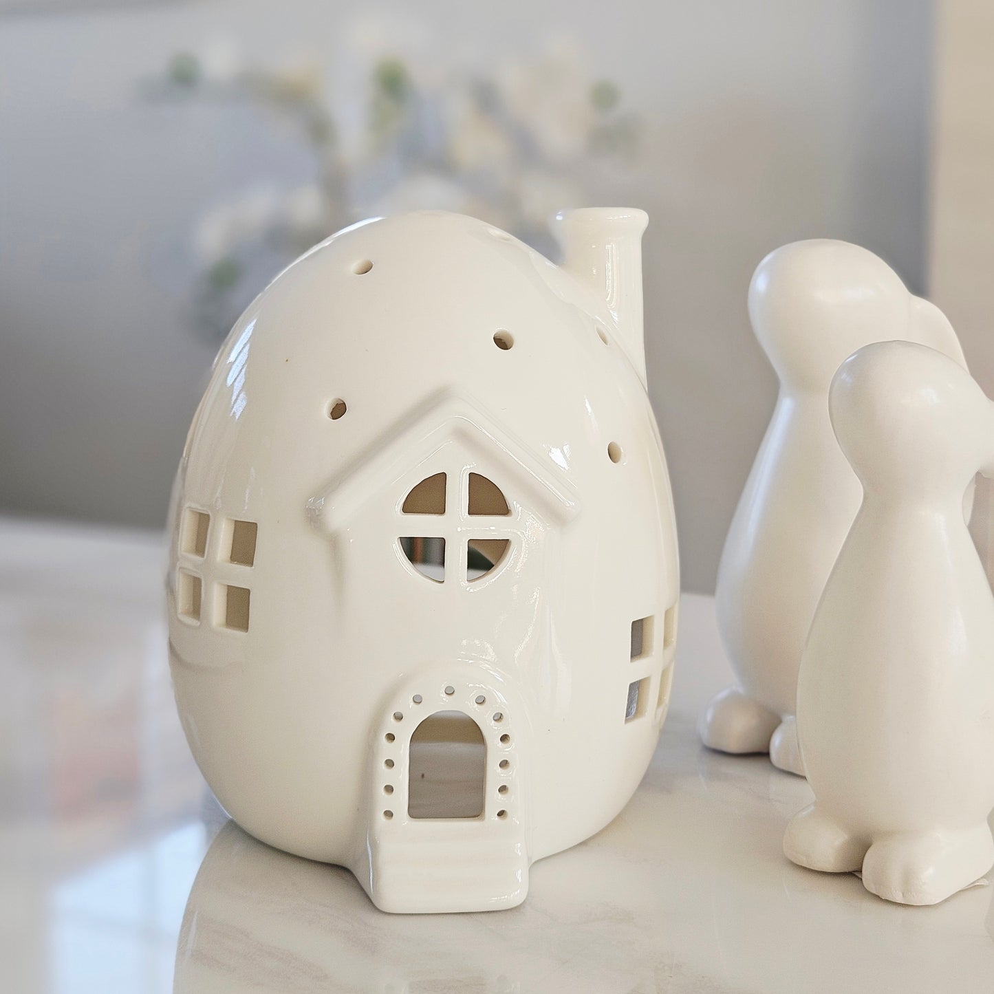 White ceramic egg shaped tea light house-shaped lantern 