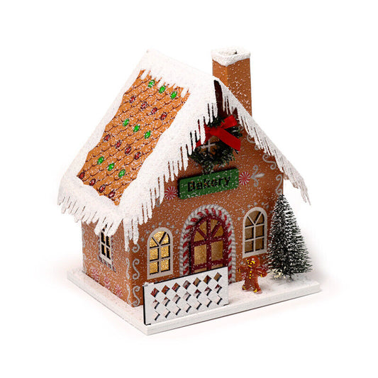 led gingerbread bakery house with snow effect and gingerbread man and christmas tree outside