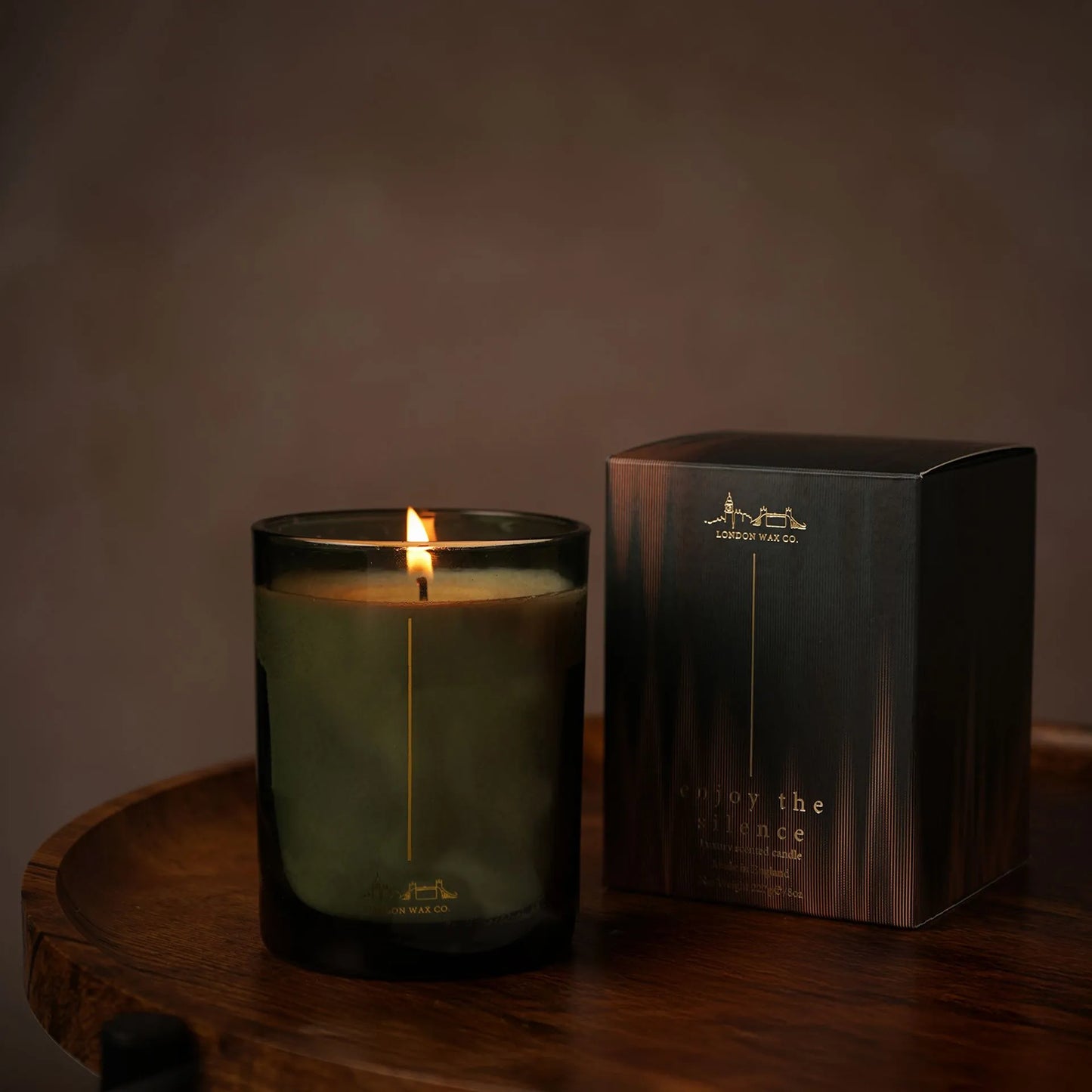 Candle in a glass jar with a box labeled London wax company enjoy the silence