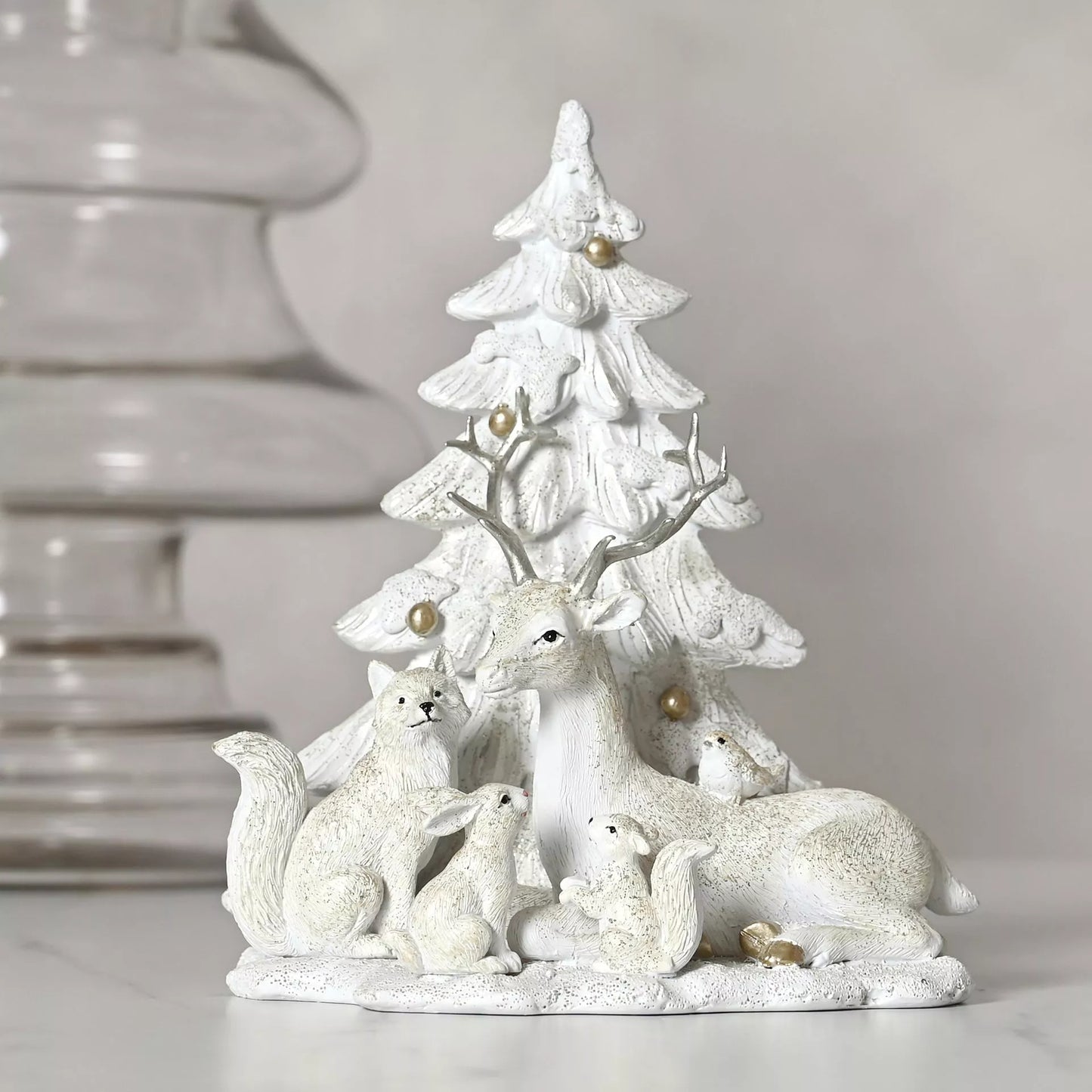 White ceramic deer, rabbit and squirrel figurine with a Christmas tree with gold balls