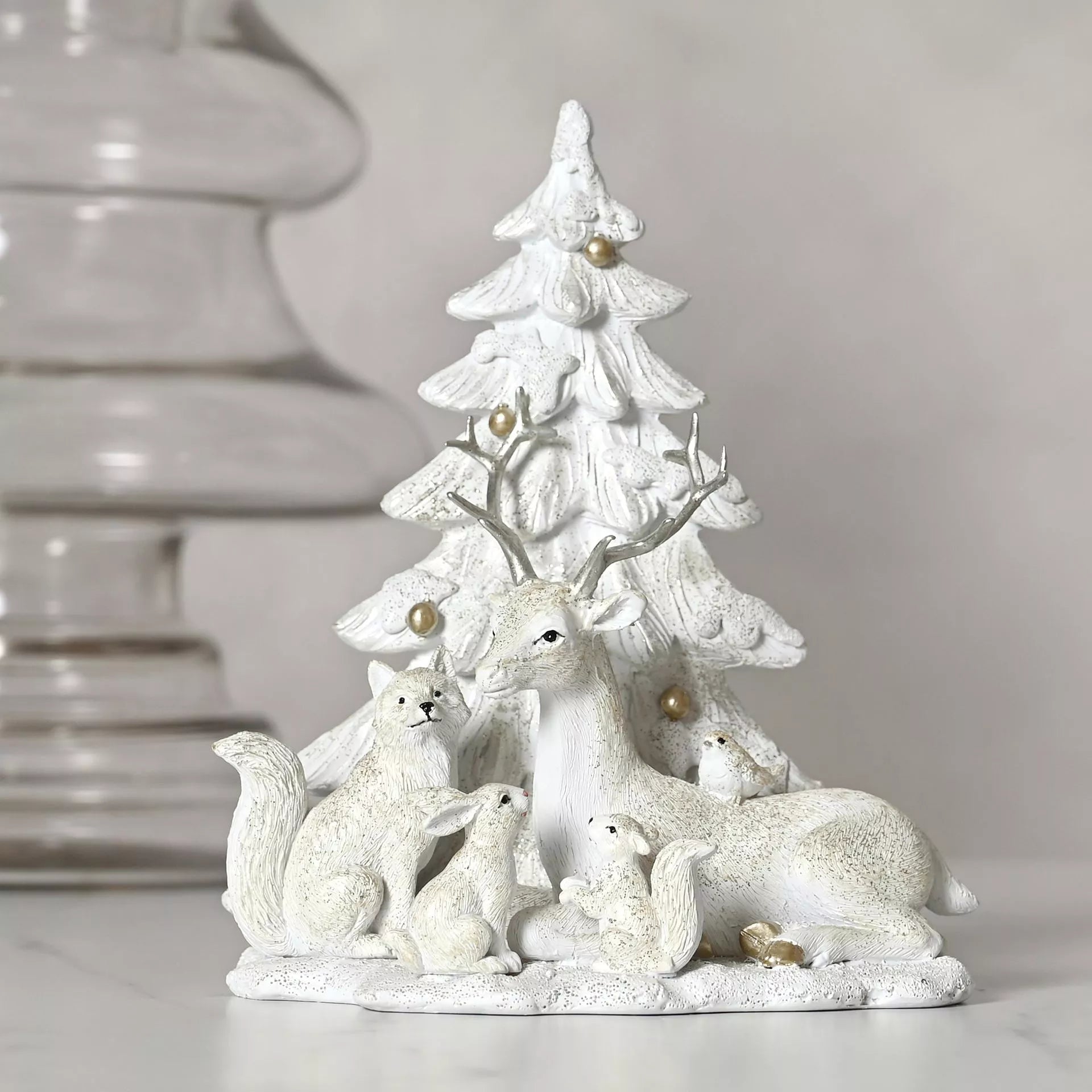 White ceramic deer, rabbit and squirrel figurine with a Christmas tree with gold balls