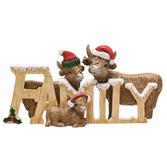 Three Highland cattle figures wearing Christmas hats behind a wooden fence with 'FAMILY' letters on a white background.